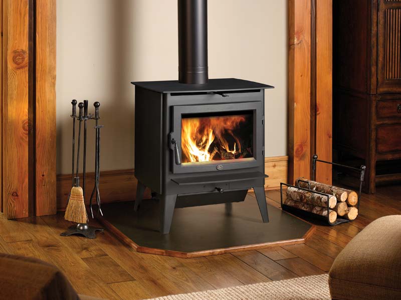 Evergreen Wood Stove in flanked by wood and chimney tools