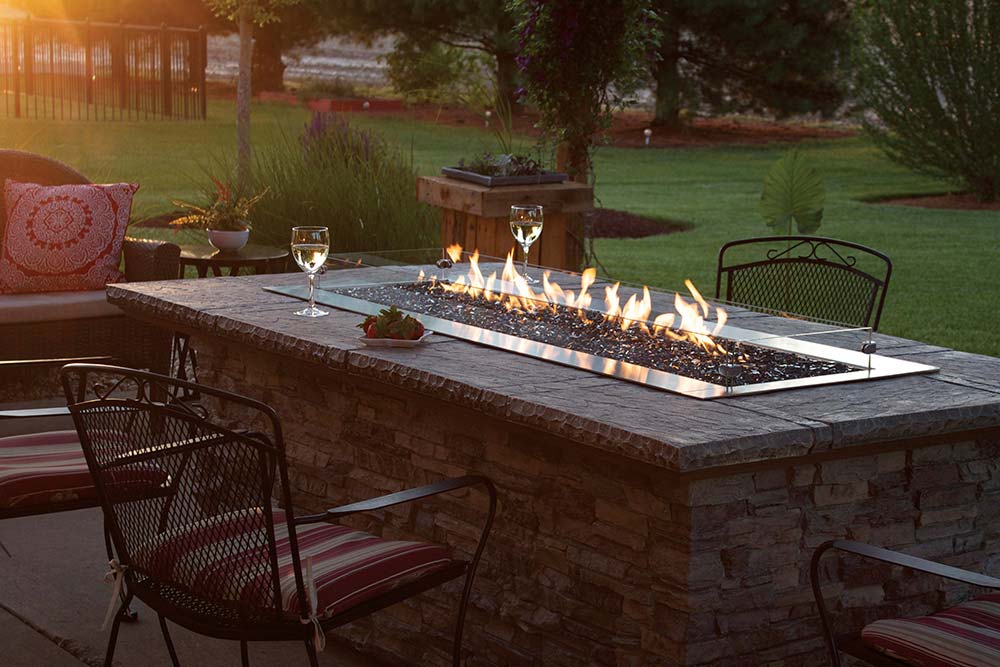Outdoor fireplace set up with glasses of white wine