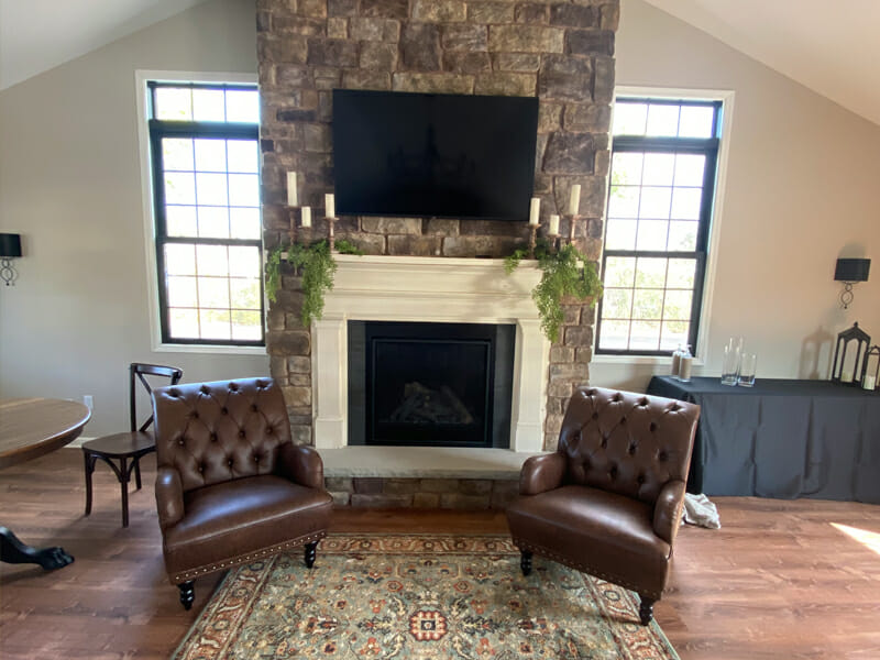 Two leather chairs on a rug in front of a fireplace