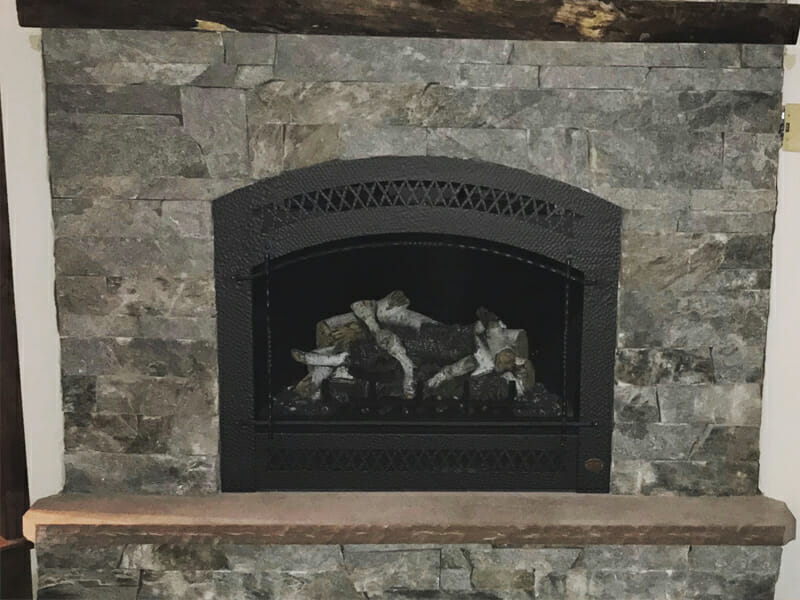 Stainless steel front of fireplace installed in brick