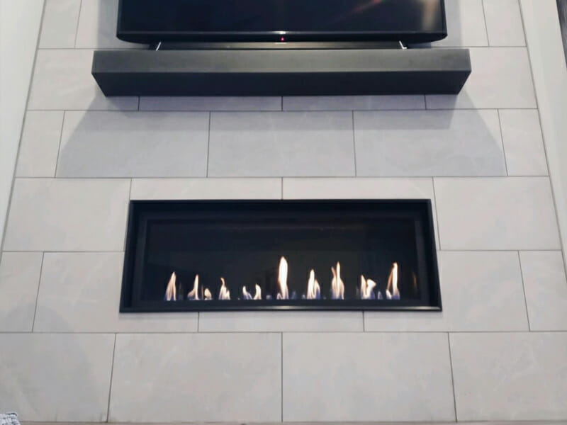 A fireplace built into the wall beneath a TV
