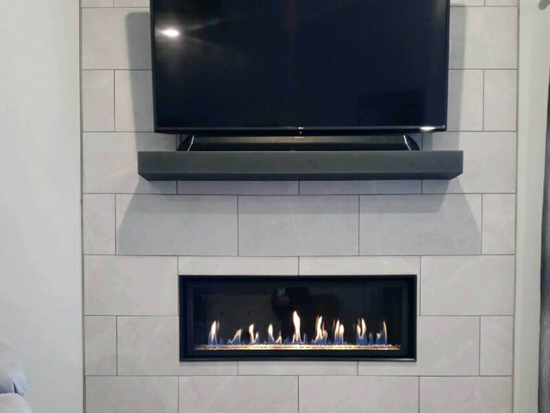 A fireplace built into the wall beneath a TV