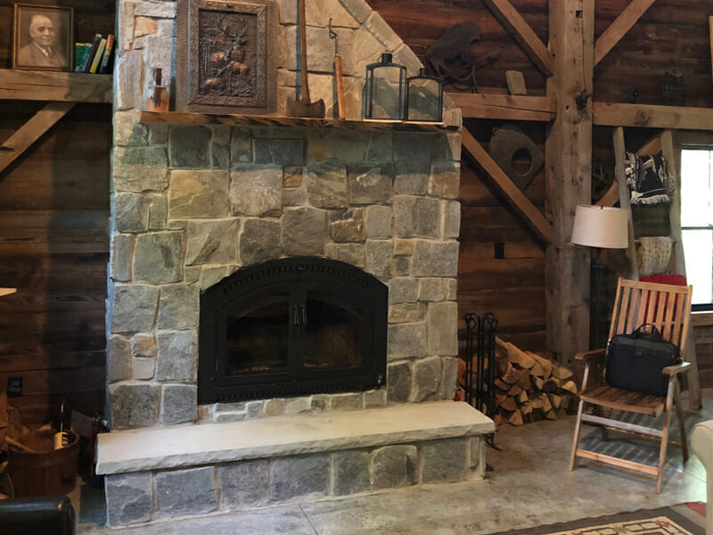 Tall stone fireplace in wooden structure