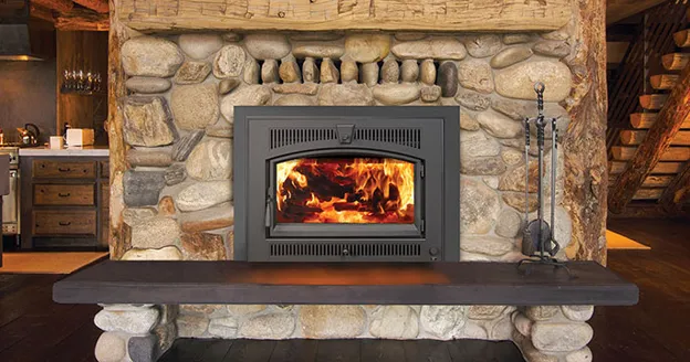 Wood-burning fireplace insert in rustic stone wall